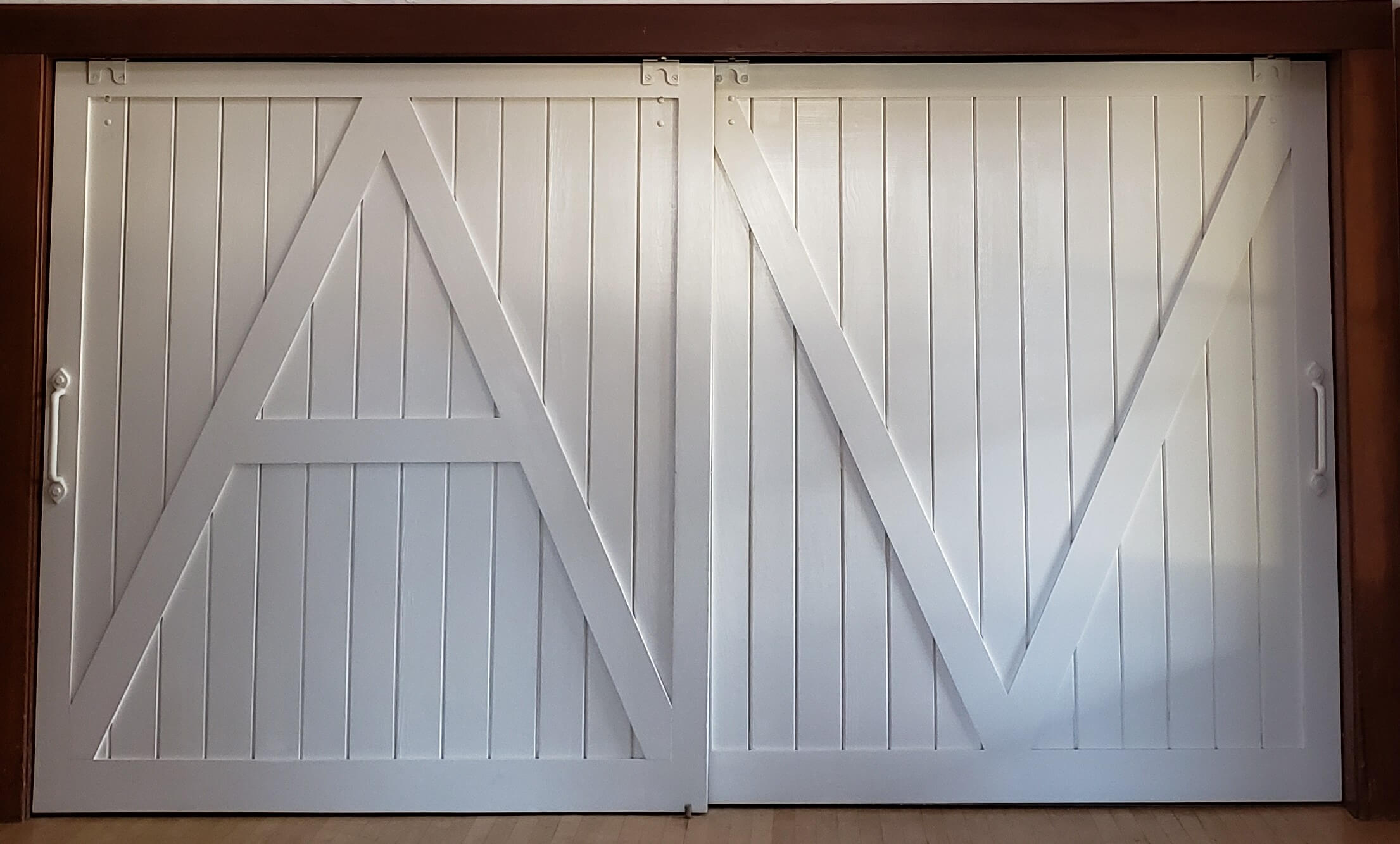 White barn doors with a large letter 'A' on the left hand door and a large letter 'V' on the right hand door
